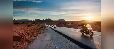 Motoristas curzando por carretera el parque tribal de los indios Navajo, con Monument Valley (Utah) al fondo. Motoristas curzando por carretera el parque tribal de los indios Navajo, con Monument Valley (Utah) al fondo.