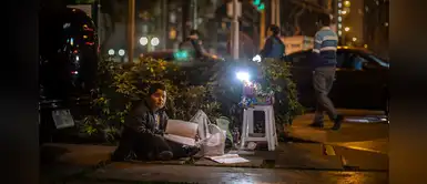 Niño hace sus tareas en la noche mientras vende dulces en las calles de Lima Niño hace sus tareas en la noche mientras vende dulces en las calles de Lima