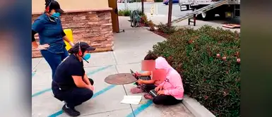 Dos niñas se sientan afuera de un restaurant para usar el Wifi gratis y hacer sus tareas Dos niñas se sientan afuera de un restaurant para usar el Wifi gratis y hacer sus tareas