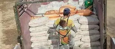 Hombre lleva en la espalda a su hijo mientras trabaja porque nadie puede cuidarlo Hombre lleva en la espalda a su hijo mientras trabaja porque nadie puede cuidarlo