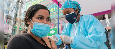 Personal de salud vacuna a joven ciudadana contra la COVID-19 en Gamarra. Minsa: Inmunización contra COVID-19 e influenza se podrán aplicar de forma simultánea