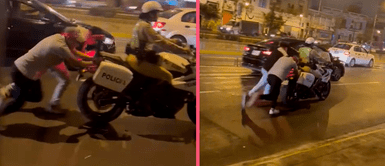Manifestantes ayudan a efectivo policial que no podía arrancar su moto lineal Manifestantes ayudan a empujar moto lineal de un efectivo policial que no podía movilizarse