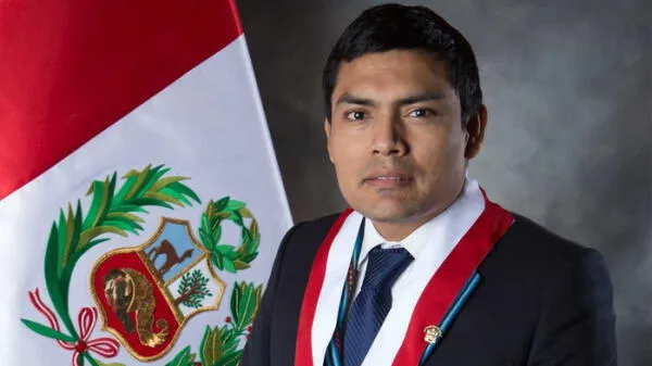 Congresista de Perú Libre Américo Gonza junto a la bandera del Perú.