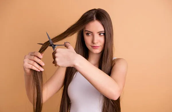 mujer con tijeras en el cabello