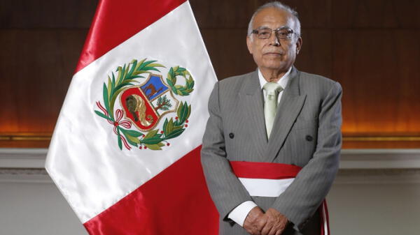 Ministro de Justicia Aníbal Torres junto a la bandera del Perú.