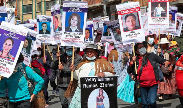 Las mujeres muestran carteles con retratos e información de acusados o sentenciados de violación, de jueces y fiscales que han liberado a implicados en casos de violencia machista o de feminicidios. Foto: EFE