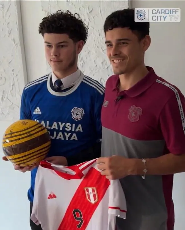 Alexander Robertson (derecha) sosteniendo la camiseta de la selección peruana.   